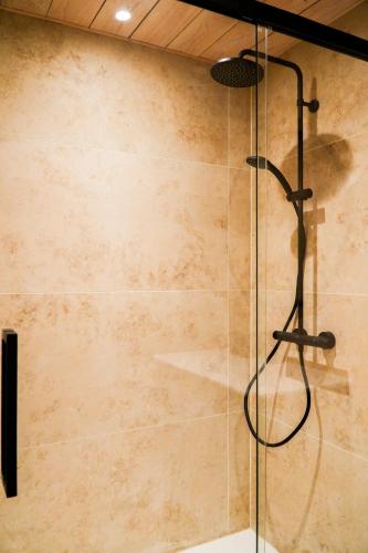 a shower with a glass door in a bathroom at B&B Heinehoeve in Kaprijke