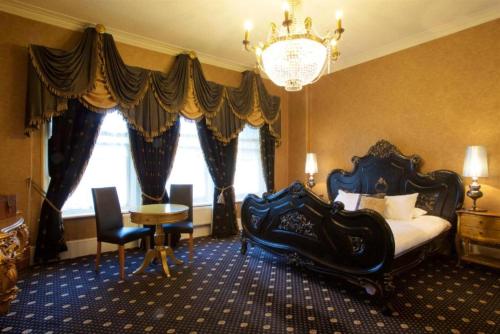 リバプールにあるLiverpool Sefton Park Hotel by Dancenterの大きなベッドとシャンデリアのある寝室