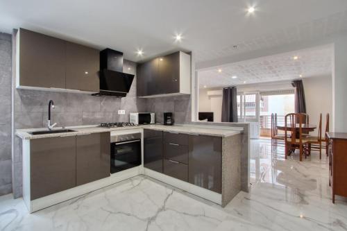 una cucina con elettrodomestici in acciaio inossidabile e una sala da pranzo di Chambre privée a Torrevieja