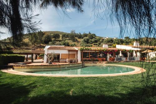 a house with a swimming pool in the yard at Monte Da Vilarinha in Carrapateira