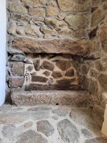 a stone wall with three stone steps in front of it at L'Orri in Dorres