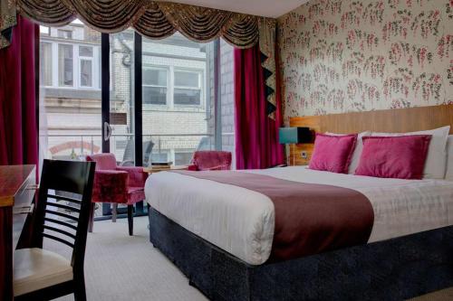 a bedroom with a bed and a desk and a window at Fenwick Street Hotel by EPIC in Liverpool