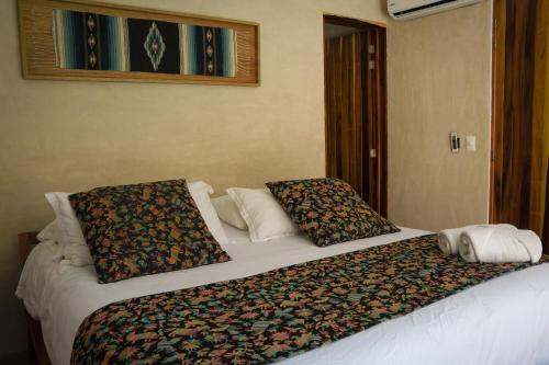 a bed in a hotel room with two pillows on it at Villa Noyollo - Alberca Privada - Punta Pérula in Pérula