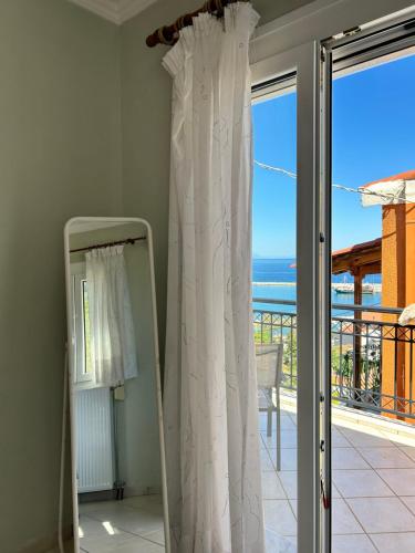 a mirror in a room with a view of the ocean at Daisy Maisonette in Póros Kefalonias