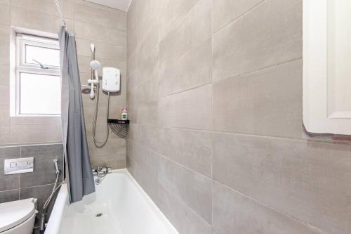 a bathroom with a toilet and a bath tub at Burley Guest House in Headingley