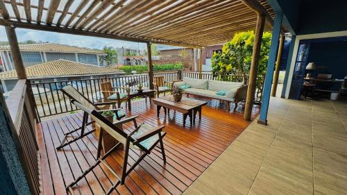 a covered deck with a couch and a table at Pousada Alto da Floresta Noronha by Alto da Ilha in Fernando de Noronha
