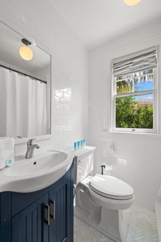 a bathroom with a sink and a toilet and a window at The Adaline - Entire Complex In Hyde Park in Tampa
