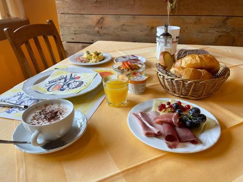 a table with plates of breakfast food and a cup of coffee at Hotel Arkanum in Salgesch