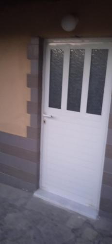 a white garage door with windows on a building at Σπίτι στα Έλατα in Palaiochórion