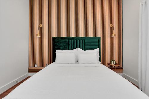 a bedroom with a large bed with a green headboard at AMAZING ROOFTOP! DOWNTOWN SKYLINE VIEWS!!! SLEEPS 15 in Houston