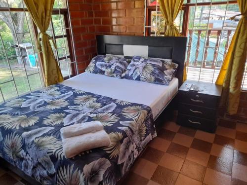 a bedroom with a bed with a blue and white comforter at Casa campestre el samán in Utica