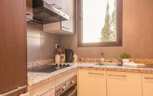 a kitchen with a sink and a stove and a window at Waky Club - Fabulous Flat in Sraghna