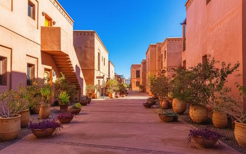 an empty alley with potted plants on the sides of buildings at Waky Club - Fabulous Flat in Sraghna