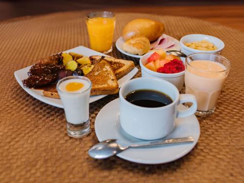 a table with a plate of breakfast food and a cup of coffee at ibis Trujillo in Trujillo