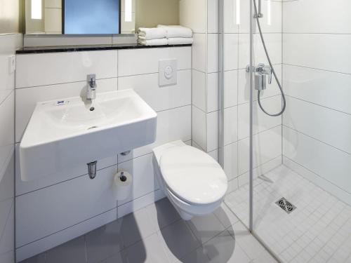 a bathroom with a toilet and a sink and a shower at ibis budget Bayreuth in Bayreuth