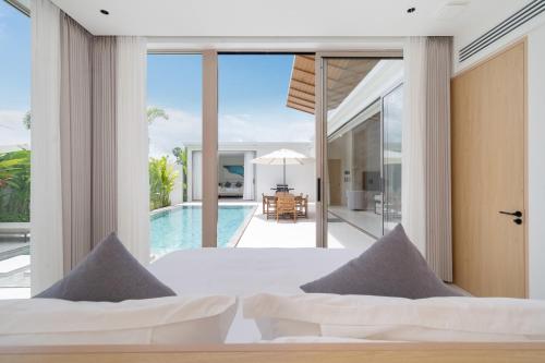 a bedroom in a villa with a view of the pool at Luxury villa 3-4 bedroom near Bangtao beach in Phuket Town