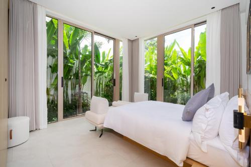 a bedroom with a white bed and large windows at Luxury villa 3-4 bedroom near Bangtao beach in Phuket Town