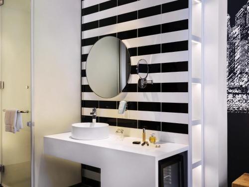 a bathroom with a white sink and a mirror at ibis Styles Dubai Airport Hotel in Dubai