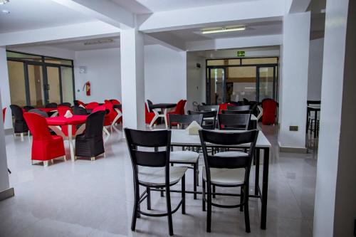a restaurant with black and red chairs and tables at Kigali Bliss Apartment in Kigali