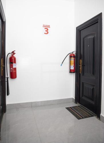 a black door and a fire extinguisher on a wall at Kigali Bliss Apartment in Kigali