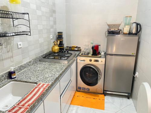 a kitchen with a refrigerator and a washing machine at Dakhla sky blue in Dakhla