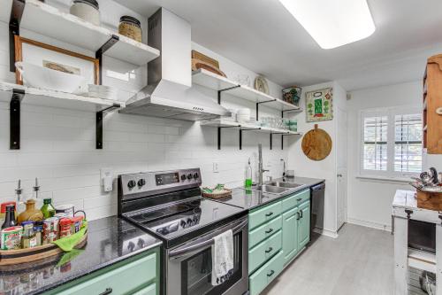 a kitchen with green cabinets and a stove top oven at Inviting Home with Golf Course View in Diamondhead! in Diamondhead