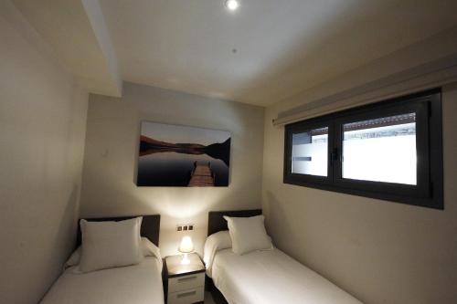 a room with two beds and a window at WinTuWin Apartments in Rialp
