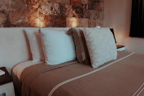 a bed with pillows on it in a room at Niken Beachfront Tulum Hotel in Tulum