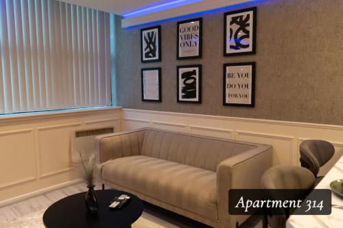 a living room with a couch and pictures on the wall at The Opulence Bradford in Bradford