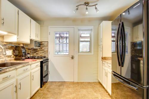 a kitchen with white cabinets and a black refrigerator at Green Valley Vacation Rental with Community Pools! in Green Valley