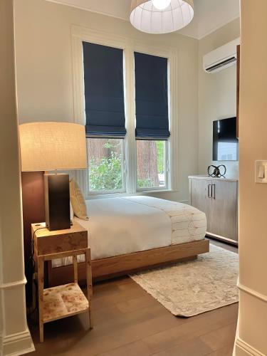 a bedroom with a bed and two windows with blue blinds at White House Napa in Napa