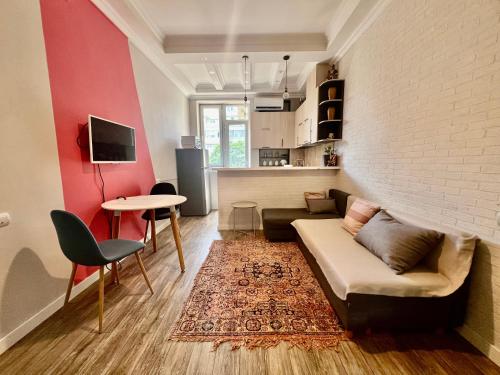 a living room with a couch and a table at Bright 1BR flat in the city centre Tsereteli ave in Tbilisi City