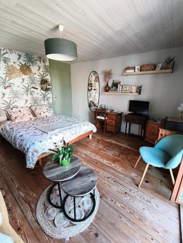 a bedroom with a bed and a table and a chair at Le Balcon de Juliette in Vuillafans