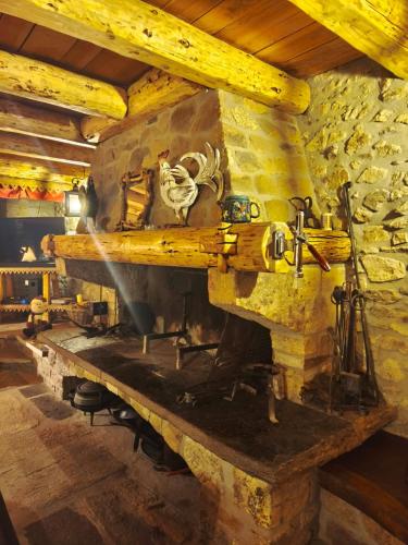 a stone fireplace in a room with a stone wall at Maison de charme à la Salvetat-sur-Agout 3 chambres in La Salvetat