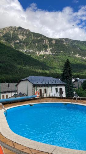 a large blue swimming pool in front of a mountain at Mira Moleta bienvenidos a Canfranc in Canfranc-Estación