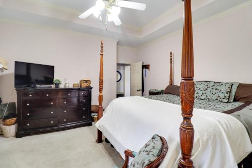a bedroom with a bed and a dresser with a television at Spacious Suburban Home with Pool Access in Ridgeland in Ridgeland