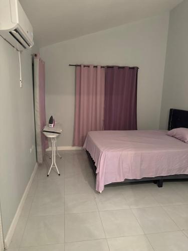 a bedroom with a bed and a table in it at Gated Fortress In Old harbour in Old Harbour