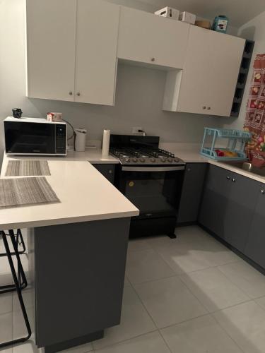 a kitchen with black appliances and white cabinets at Gated Fortress In Old harbour in Old Harbour