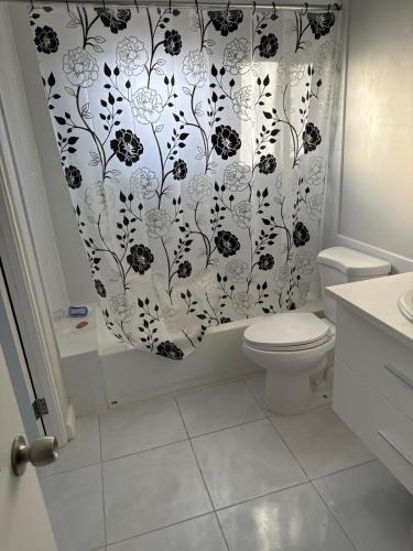 a bathroom with a black and white shower curtain at Gated Fortress In Old harbour in Old Harbour