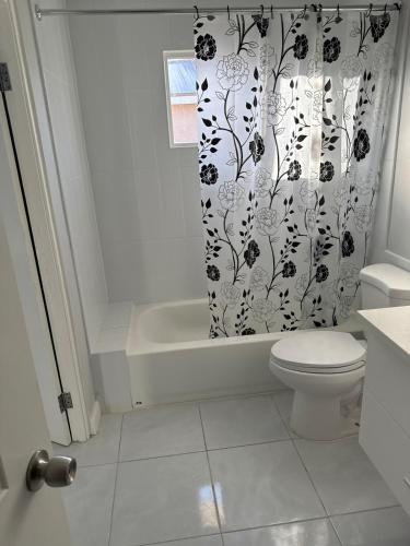 a bathroom with a toilet and a shower curtain at Gated Fortress In Old harbour in Old Harbour