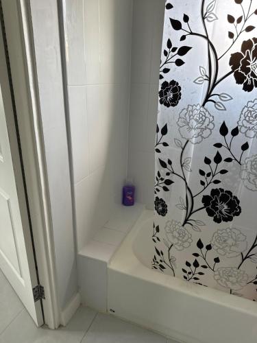 a shower curtain with a black and white floral pattern at Gated Fortress In Old harbour in Old Harbour