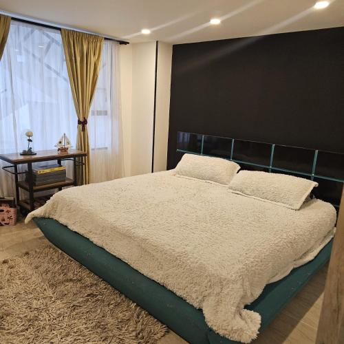 a bedroom with a large bed and a window at Restrepo 201 in Bogotá