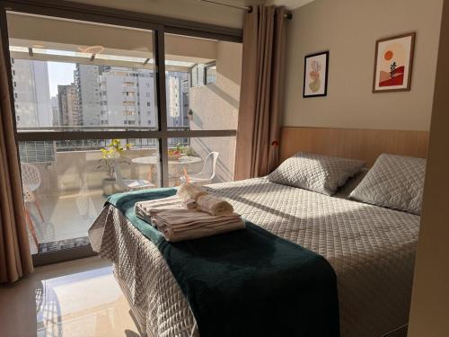 ein Schlafzimmer mit einem Bett und einem großen Fenster in der Unterkunft Flat em Moema Grand Vitrali - Aero Congonhas in São Paulo