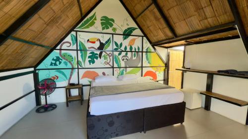 a bedroom with a bed with a mural on the wall at Glamping Horizon Forest in Anapoima