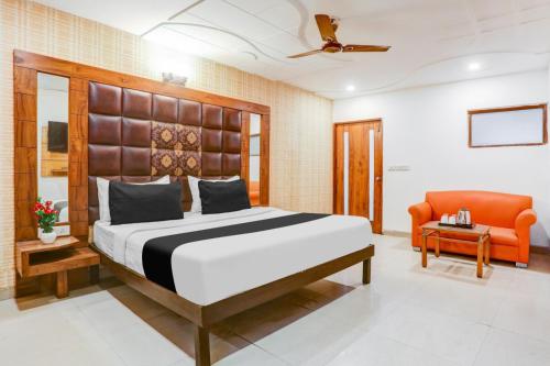 a bedroom with a large bed and a chair at Hotel Prabha Wati Palace Suites Near Kashi Vishwanath Temple in Varanasi