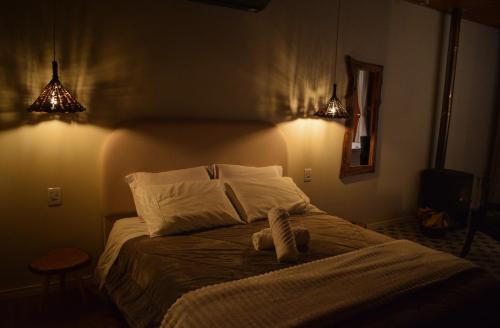 a bedroom with a bed with a teddy bear on it at Suítes Celeste, Charme no Vale dos Vinhedos com Banheira e Café da Manhã Colonial Incluso in Bento Gonçalves