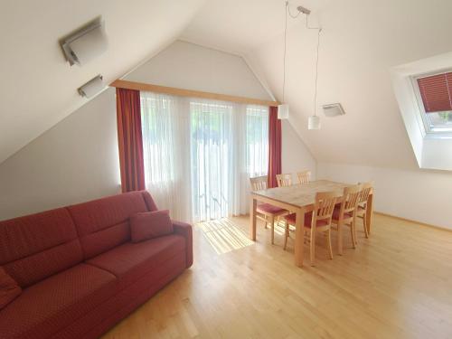 a living room with a red couch and a table at Gästehaus Eisenerz in Eisenerz
