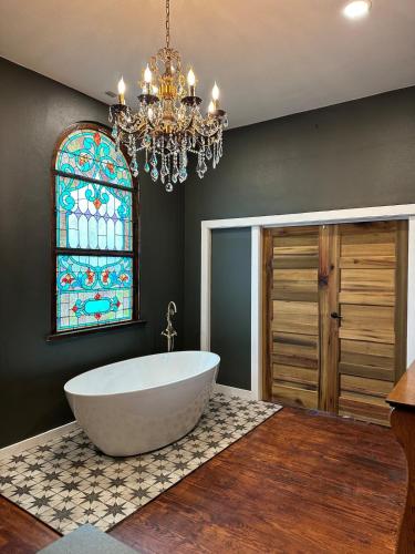 a bathroom with a large tub and a stained glass window at Lafayette's Oldest Church in Lafayette