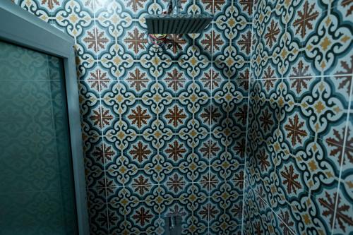 a bathroom with a blue and white tiled wall at Bungalow Salvaxia in Chichicastenango