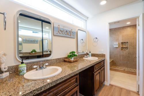une salle de bain avec deux lavabos et un grand miroir dans l'établissement Mission Casa Del Mar, à San Diego